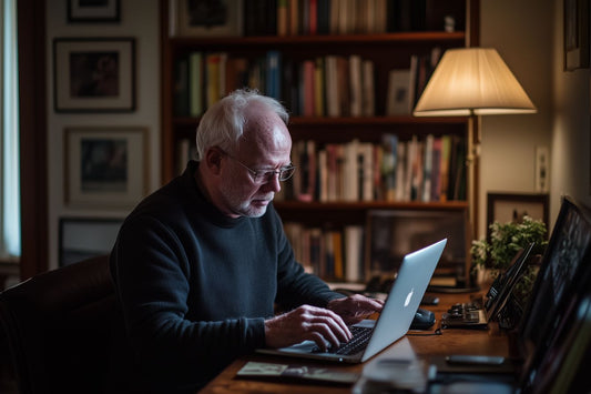 Homme âgé utilisant un ordinateur portable, illustrant l'offre de biographie numérique d'Elefantia pour écrire ses mémoires.